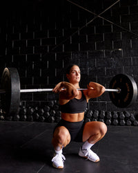 Woman wearing Genesis Layered Sports Bra - Black | Size:S