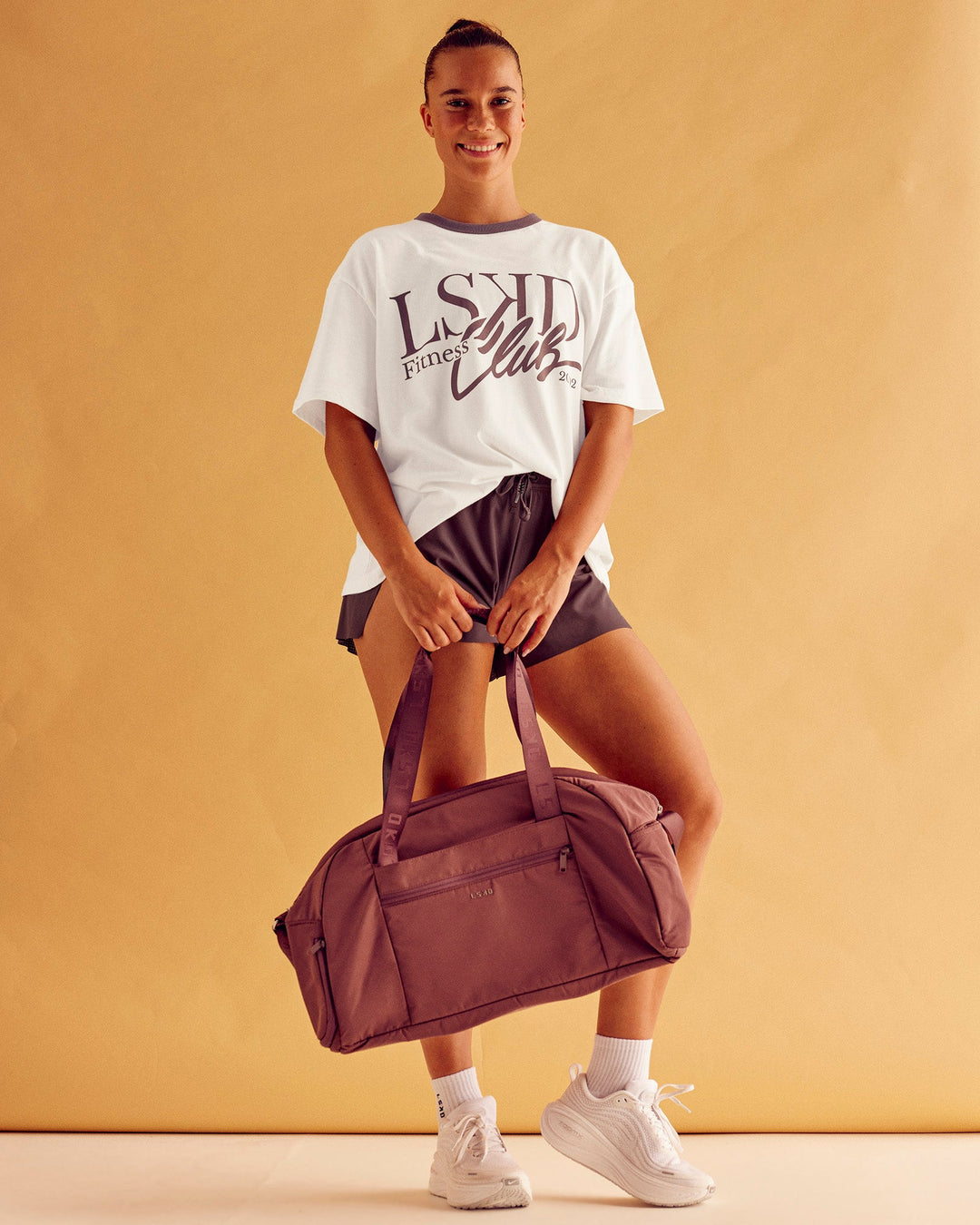 Woman wearing LSKD Fitness Club Heavyweight Oversized Tee - Off White-Cocoa Powder | Model:Charlize | Size:S