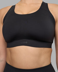 Woman wearing Stability Sports Bra - Black | Model:Amy | Size:S (D-E Cup)