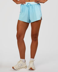 Woman wearing Accelerate 3" High-Rise Running Short - Baltic Sea-Off White | Set:true | Angle:front | Model:Emelia | Size:S