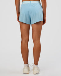 Woman wearing Accelerate 3" High-Rise Running Short - Baltic Sea-Off White | Set:true | Angle:back | Model:Emelia | Size:S