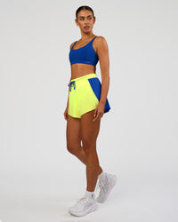 Woman wearing Accelerate 3" High-Rise Running Short - Electric Indigo-Lime Glo | Model:Ruby | Size:S