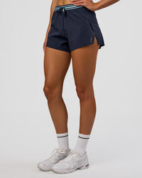 Woman wearing Accelerate 3" High-Rise Running Short - Future Navy-Baltic Sea | Set:true | Angle:side | Model:Evie | Size:S