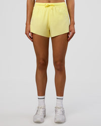 Woman wearing Accelerate 3" High-Rise Running Short - Yellow Fizz | Set:true | Angle:front | Model:Evie | Size:S