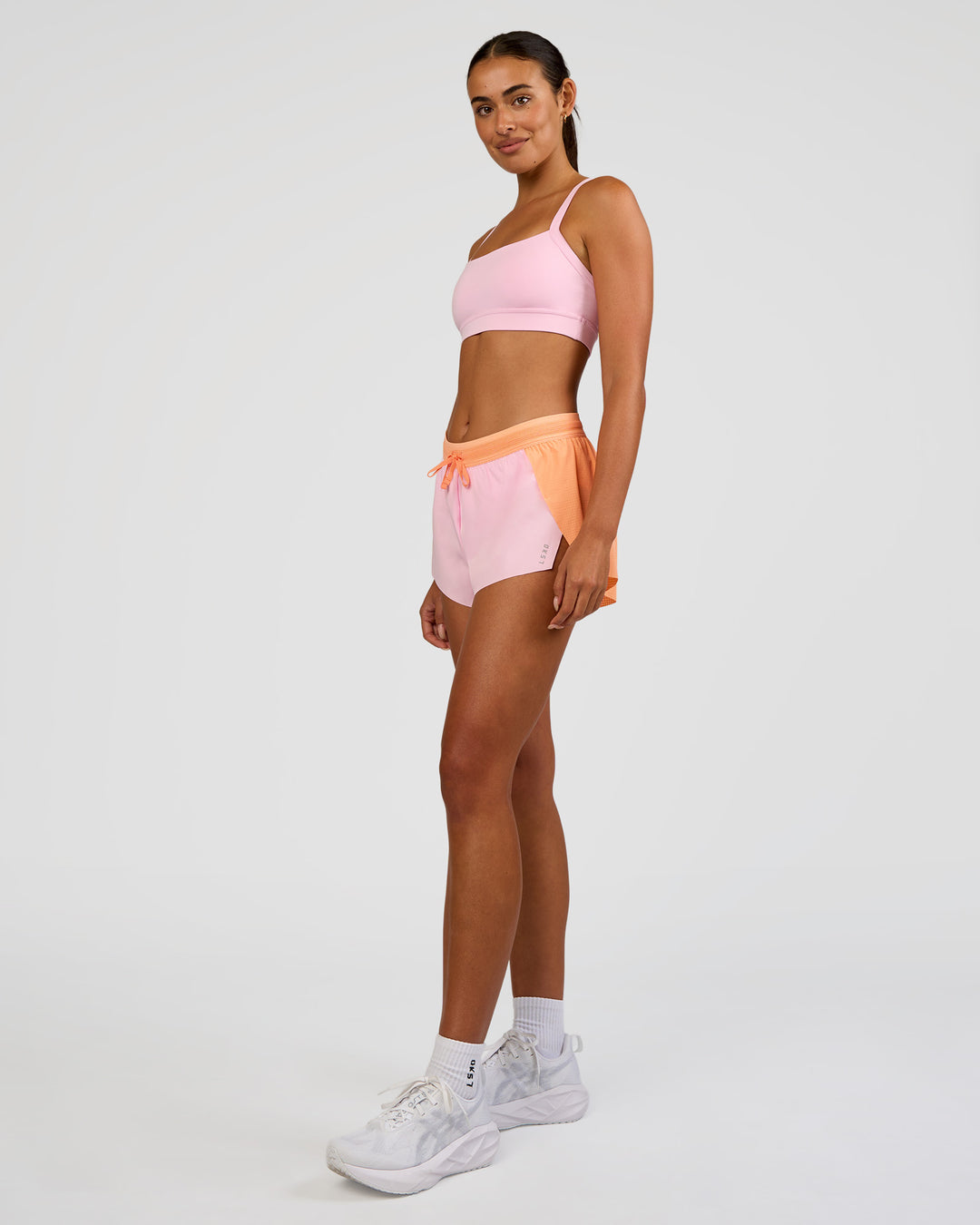 Woman wearing Accelerate 3" Mid-Rise Running Short - Cantaloupe-Marshmallow | Model:Ruby | Size:S