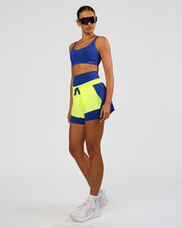 Woman wearing Accelerate 3" Mid-Rise Running Short - Electric Indigo-Lime Glo | Model:Ruby | Size:S