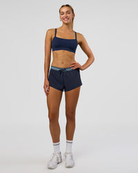 Woman wearing Accelerate 3" Mid-Rise Running Short - Future Navy-Baltic Sea | Model:Evie | Size:S