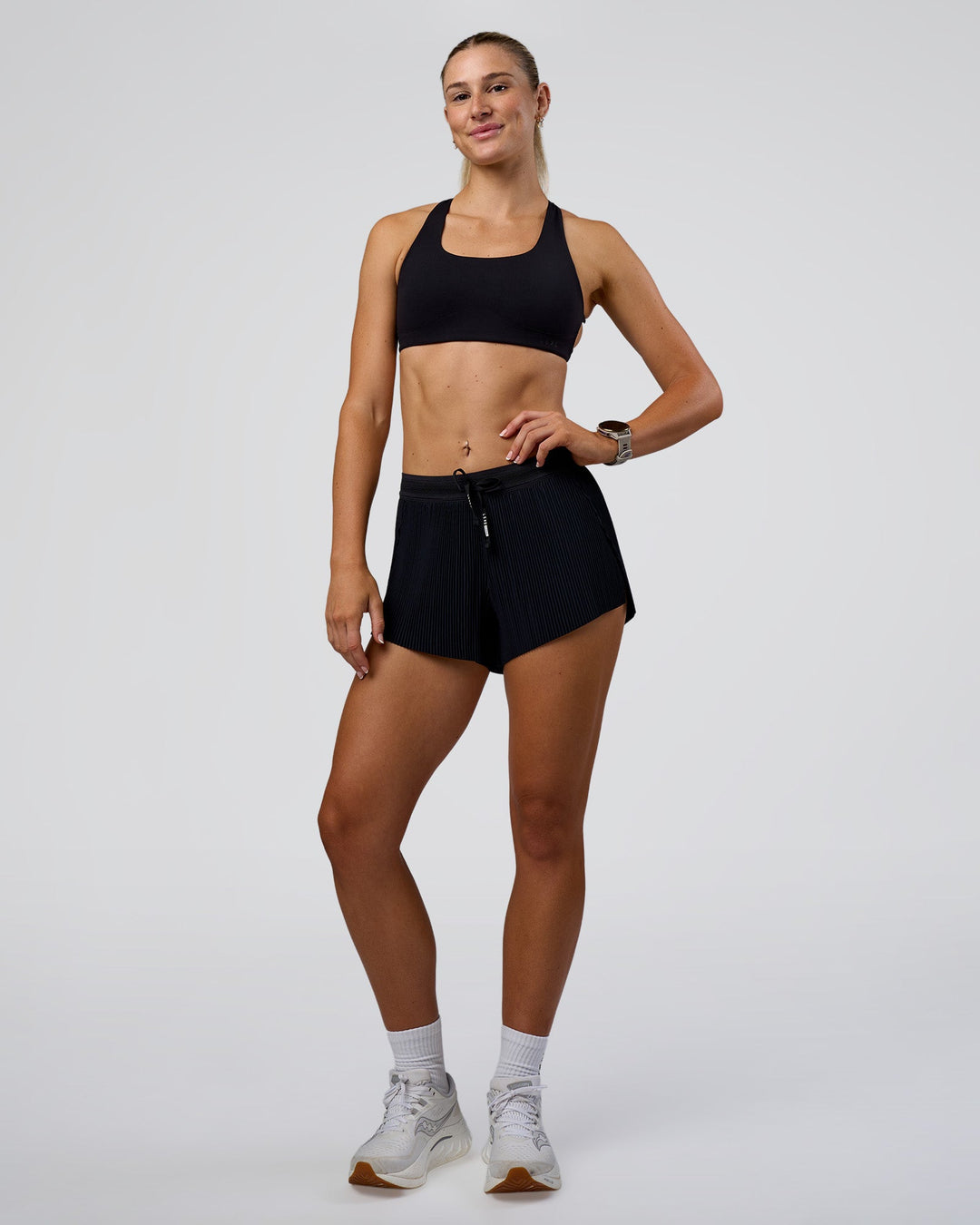Woman wearing Accelerate 3" Pleated Mid-Rise Running Short - Black | Model:Emelia | Size:S