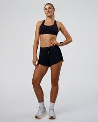 Woman wearing Accelerate 3" Pleated Mid-Rise Running Short - Black | Model:Emelia | Size:S