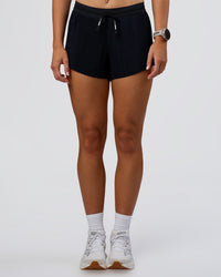 Woman wearing Accelerate 3" Pleated Mid-Rise Running Short - Black | Model:Emelia | Size:S