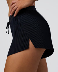 Woman wearing Accelerate 3" Pleated Mid-Rise Running Short - Black | Model:Emelia | Size:S