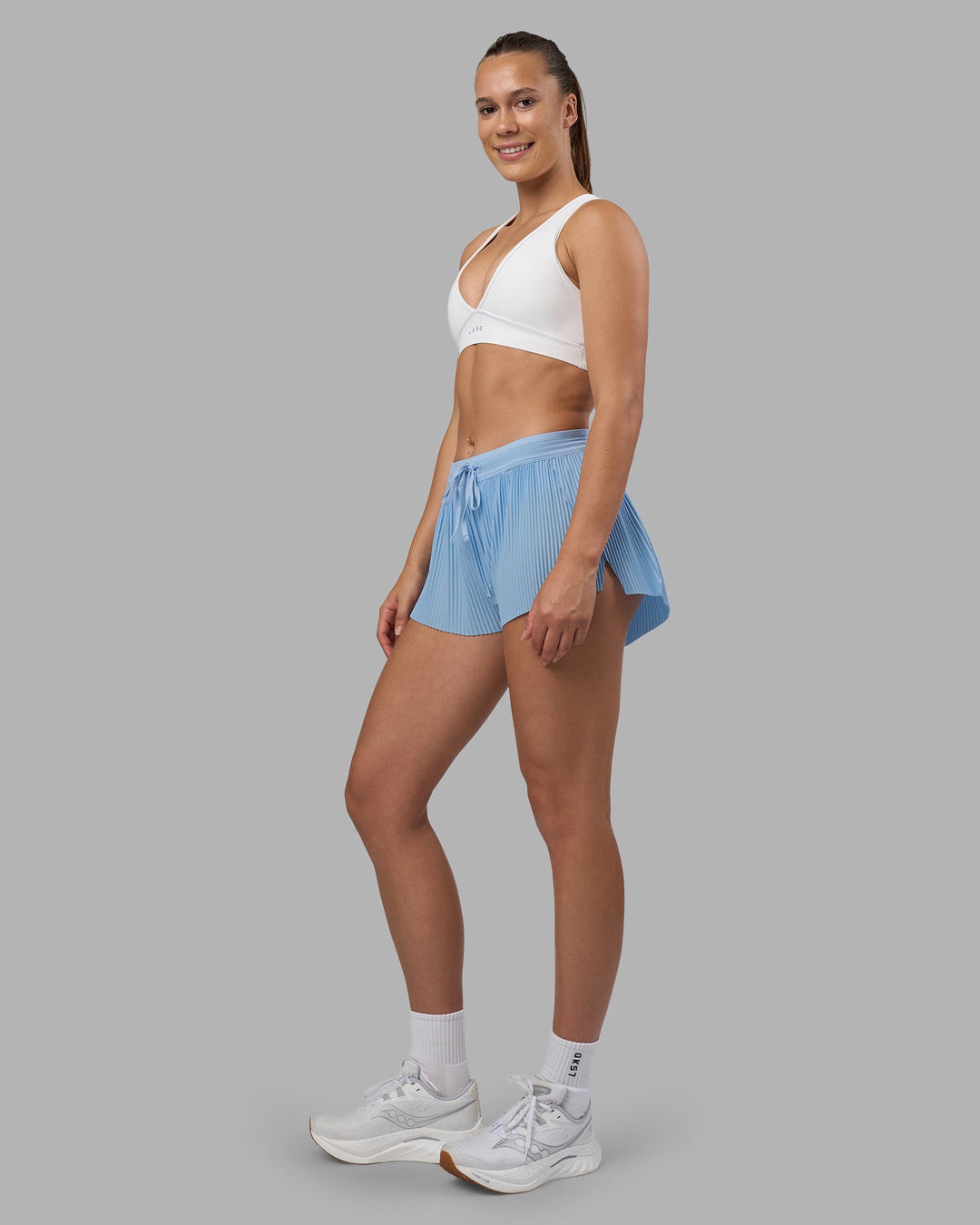 Woman wearing Accelerate 3" Pleated Running Short - Open Air | Model:Charlize | Size:S