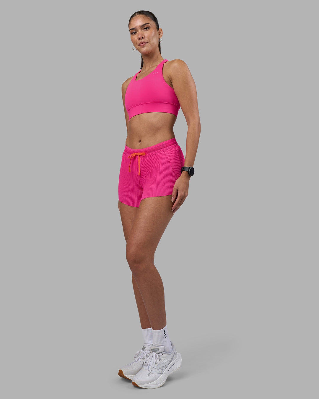 Woman wearing Accelerate 3&quot; Pleated Running Short - Ultra Pink | Model:Rhiley | Size:S