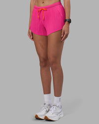 Woman wearing Accelerate 3" Pleated Running Short - Ultra Pink | Model:Rhiley | Size:S