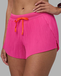 Woman wearing Accelerate 3" Pleated Running Short - Ultra Pink | Model:Rhiley | Size:S