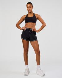 Woman wearing Accelerate 3" Reflective High-Rise Running Short - Black-Reflective | Model:Rosie | Size:S