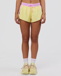 Woman wearing Accelerate 3" Mid-Rise Running Short - Marshmallow-Lemon | Set:true | Angle:front | Model:Grace | Size:S