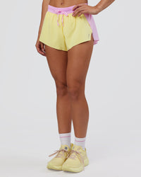 Woman wearing Accelerate 3" Mid-Rise Running Short - Marshmallow-Lemon | Set:true | Angle:side | Model:Grace | Size:S
