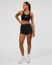 Woman wearing Accelerate Graphic Sports Bra - Black-Radiate | Model:Rosie | Size:S