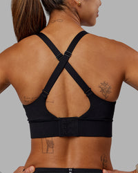 Woman wearing Accelerate Sports Bra - Black | Set:true | Angle:back | Model:Vanessa | Size:S