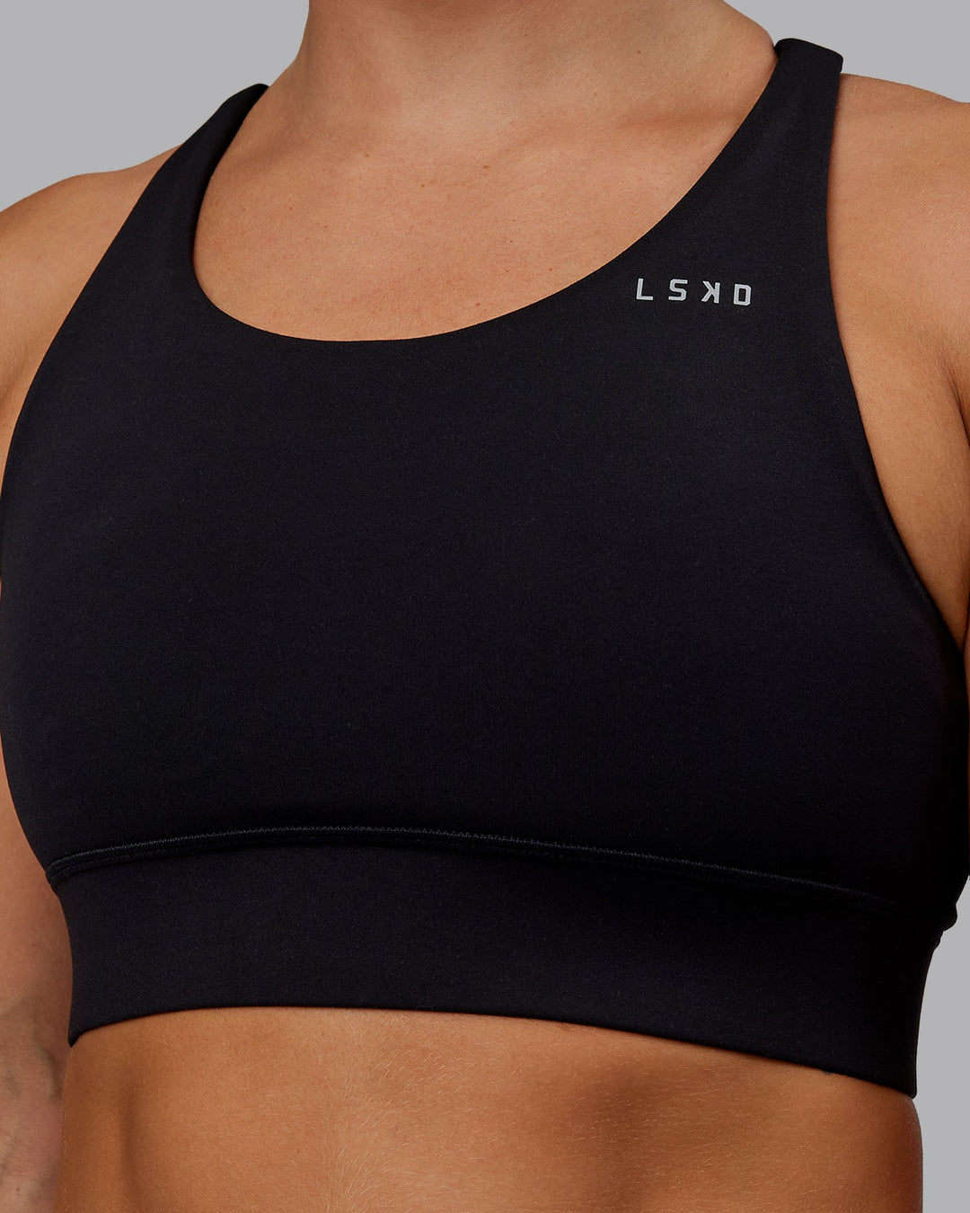 Woman wearing Accelerate Sports Bra - Black | Set:true | Angle:closeup | Model:Lyss | Size:S