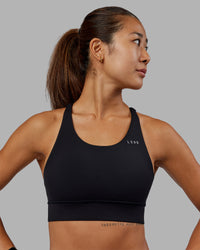 Woman wearing Accelerate Sports Bra - Black | Set:true | Angle:front | Model:Vanessa | Size:S