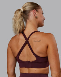 Woman wearing Accelerate Sports Bra - Cherry Lacquer | Set:true | Angle:back | Model:Hannah | Size:S
