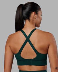 Woman wearing Accelerate Sports Bra - Dark Moss | Set:true | Angle:back | Model:Rhiley | Size:S