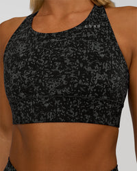Woman wearing Accelerate Sports Bra - Energy Print Black | Set:true | Angle:closeup | Model:Amity | Size:S