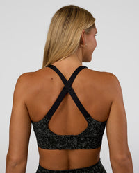 Woman wearing Accelerate Sports Bra - Energy Print Black | Set:true | Angle:back | Model:Amity | Size:S
