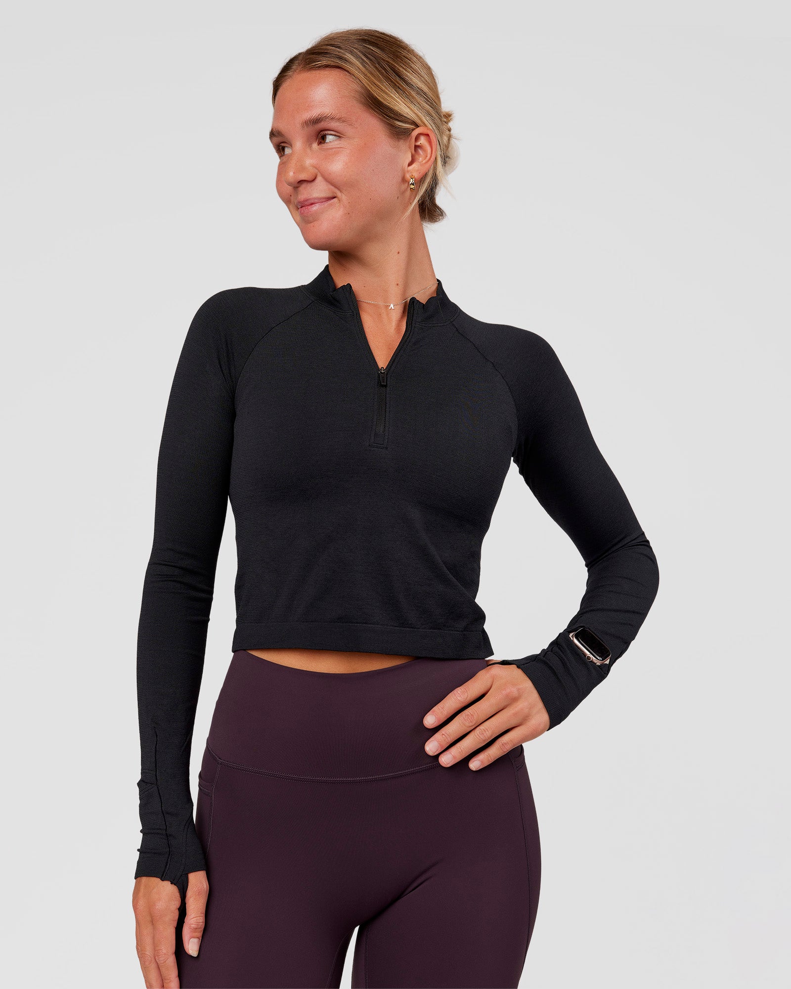 Woman wearing AeroFLX+ Long Sleeve Skimmer Half Zip - Black Marl | Model:Amity | Size:S