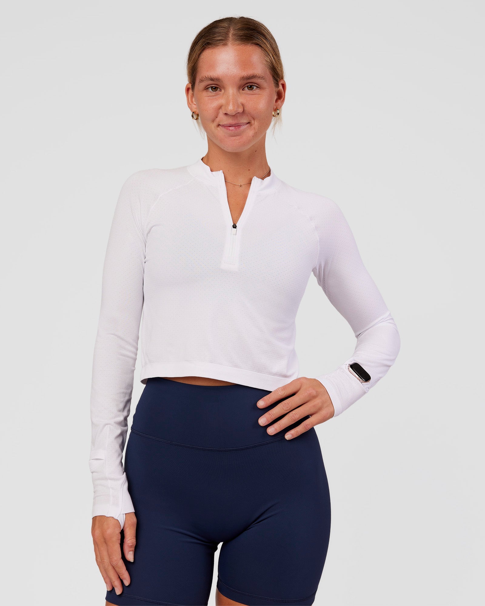 Woman wearing AeroFLX+ Long Sleeve Skimmer Half Zip - White/White | Model:Amity | Size:S