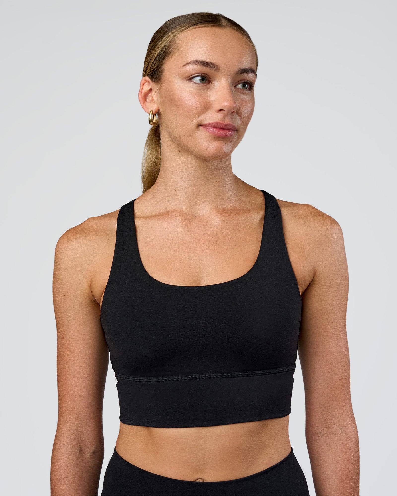 Woman wearing Circuit Longline Sports Bra - Black | Model:Evie | Size:S