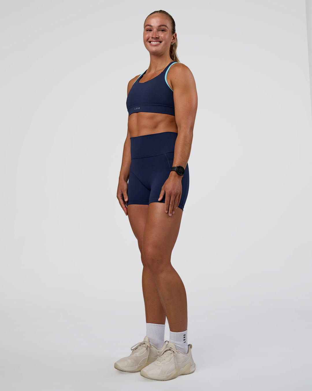 Woman wearing Distinction Sports Bra 2.0 - Future Navy-Baltic Sea | Model:Sav | Size:S