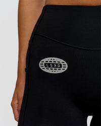 Woman wearing Elite Hype Reflective Run High-Rise 5" Short Pockets - Black-Hype Reflective | Model:Amity | Size:S