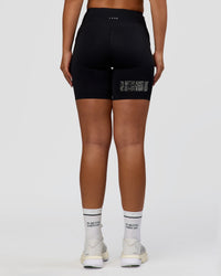 Woman wearing Elite Hype Reflective Run High-Rise 7" Short Pockets - Black-Hype Reflective | Model:Sophia | Size:S