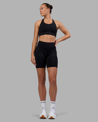 Woman wearing Elite Run High-Rise 7" Short Pockets - Black | Model:Charlize | Size:S