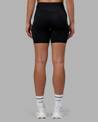 Woman wearing Elite Run High-Rise 7" Short Pockets - Black | Model:Charlize | Size:S