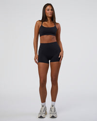 Woman wearing Elixir Defined High-Rise 4" Short Pockets - Black | Model:Bianca | Size:S