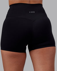 Woman wearing Elixir High-Rise 4" Short - Black | Model:Rhiley | Size:S