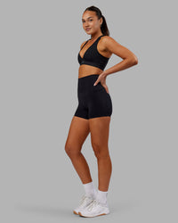 Woman wearing Elixir Ultra High-Rise 4" Short Pockets - Black | Model:Kirstyn | Size:S