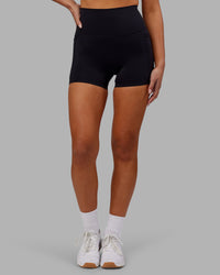 Woman wearing Elixir Ultra High-Rise 4" Short Pockets - Black | Model:Kirstyn | Size:S
