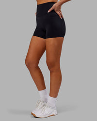 Woman wearing Elixir Ultra High-Rise 4" Short Pockets - Black | Model:Kirstyn | Size:S