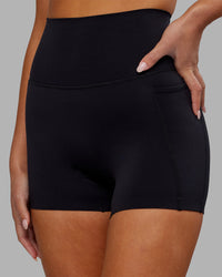 Woman wearing Elixir Ultra High-Rise 4" Short Pockets - Black | Model:Kirstyn | Size:S