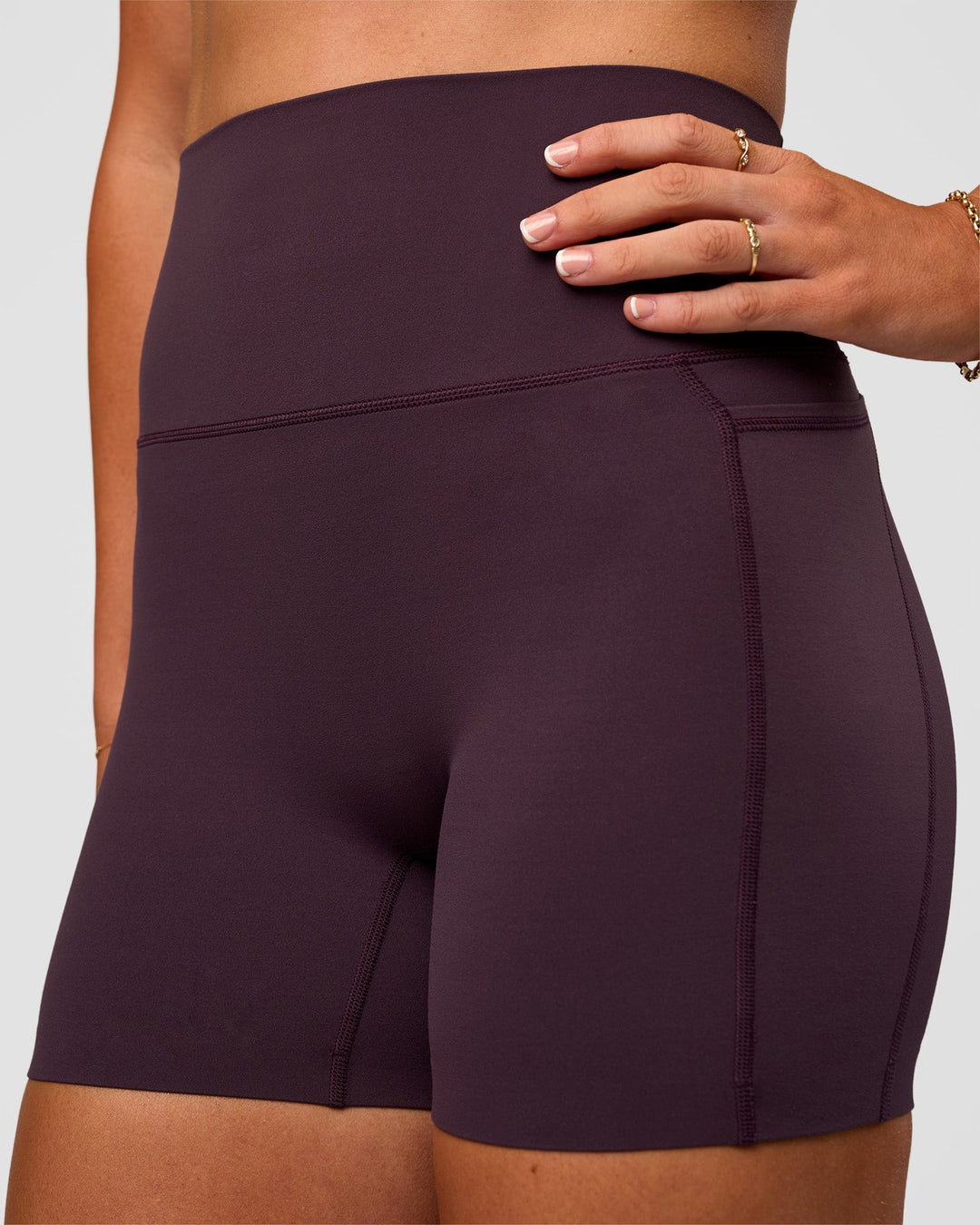 Woman wearing Elixir Ultra High-Rise 4" Short Pockets - Midnight Plum | Model:Emelia | Size:S