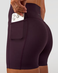 Woman wearing Elixir Ultra High-Rise 4" Short Pockets - Midnight Plum | Model:Emelia | Size:S