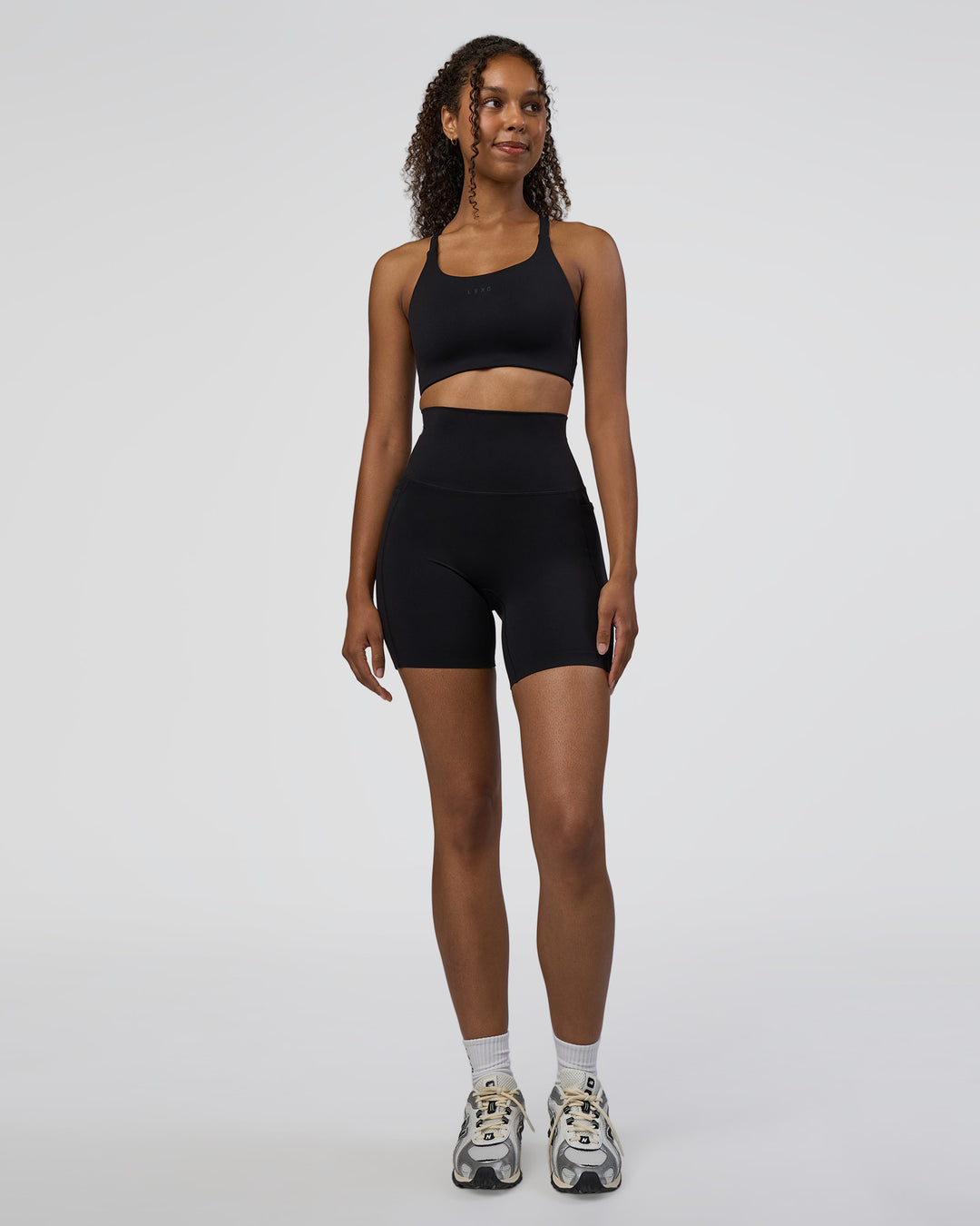 Woman wearing Elixir Ultra High-Rise 6&quot; Short Pockets - Black | Model:Jordan | Size:S