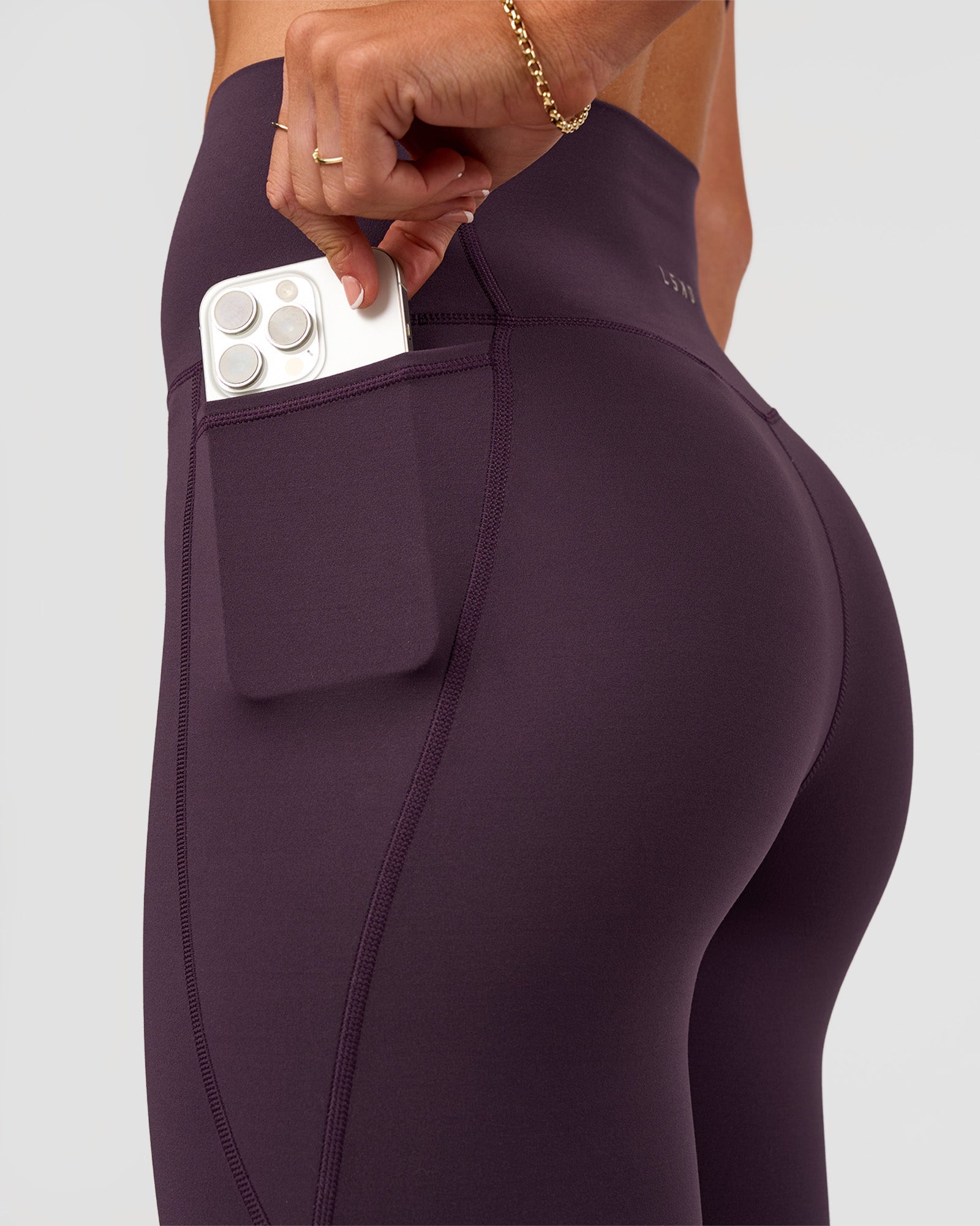 Woman wearing Elixir Ultra High-Rise 7/8 Legging Pockets - Midnight Plum | Model:Emelia | Size:S