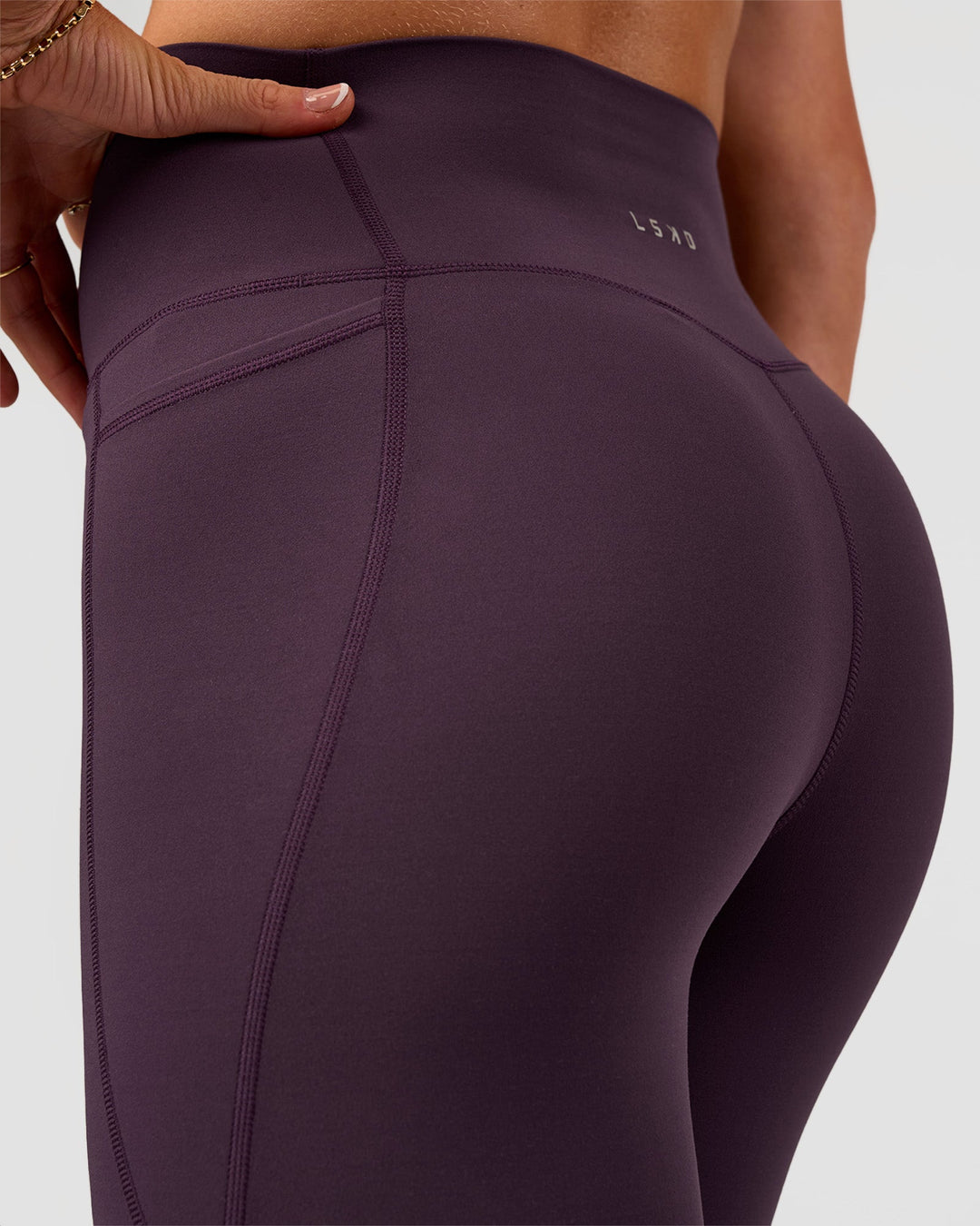 Woman wearing Elixir Ultra High-Rise 7/8 Legging Pockets - Midnight Plum | Model:Emelia | Size:S