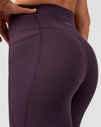 Woman wearing Elixir Ultra High-Rise 7/8 Legging Pockets - Midnight Plum | Model:Emelia | Size:S